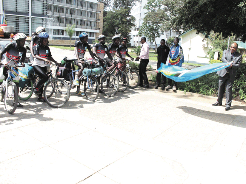 EAC Deputy Secretary General in charge of Political Federation,  Charles Njoroge (R), flags off the 14 cyclists at the EAC Headquarters in Arusha. (Courtesy)