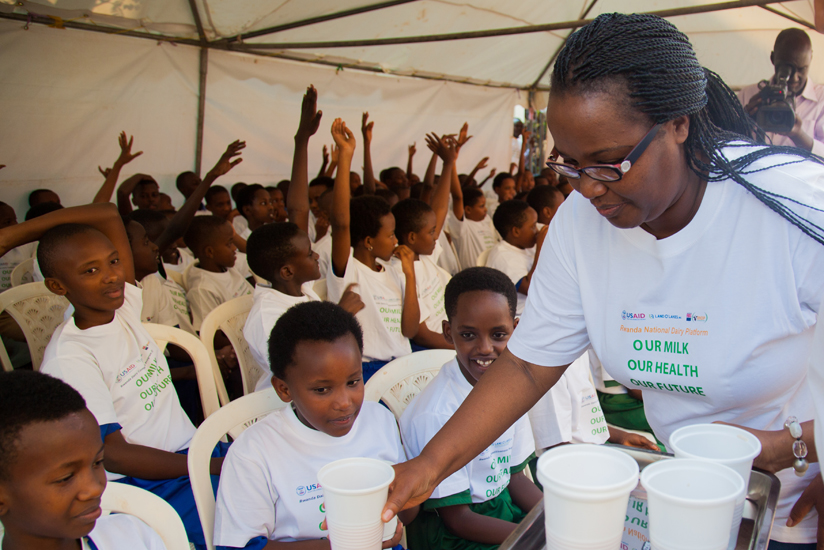Mukeshimana serves milk to schoolchildren during the launch of the campaign to raise awareness of the importance of drinking milk in Kigali yesterday. (Nadege Imbabazi)