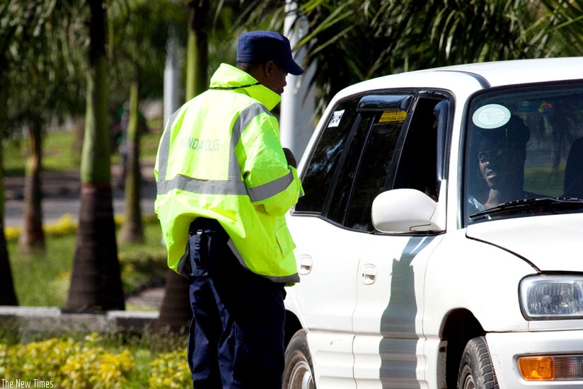 A Traffic Police officer questions a motorist. RNP says it will be deploying officers in plain clothes in unmarked Police vehicles to keep errant motorists in check. / Tinothy Kisambira.