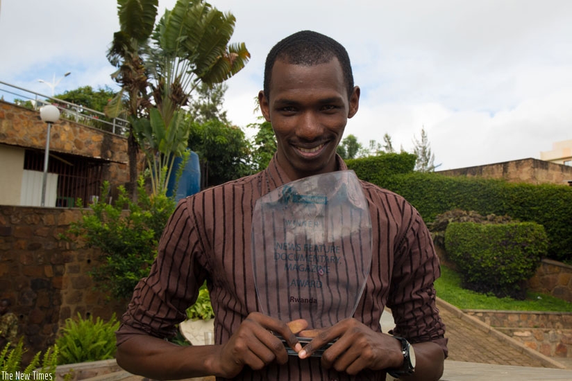 Video-photojournalist Faustin Niyigena holds his award as the winner in News Feature, Documentary and Magazine category during Development Journalism Competition in 2015 in Rwanda.....