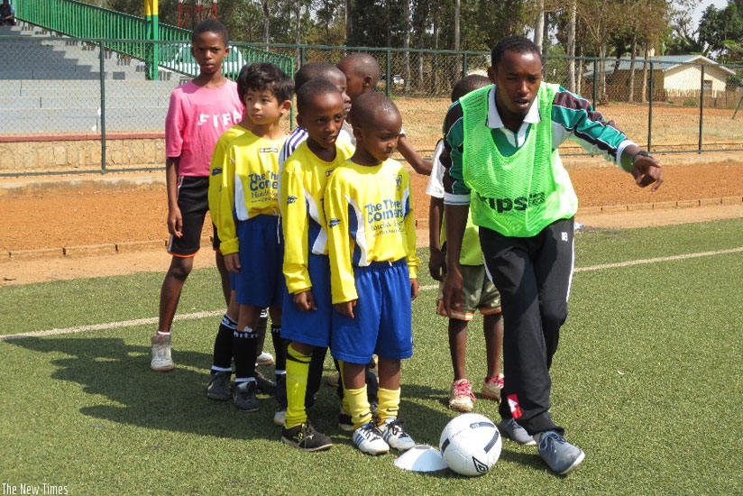 A coach gives instructions to young Rwandan football talents under a Dream Team Football Academy initiative in 2013. (Net photo)