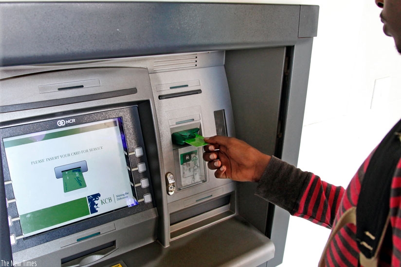 A KCB client uses an ATM. The number of ATMs has increased by 10%. (File.)