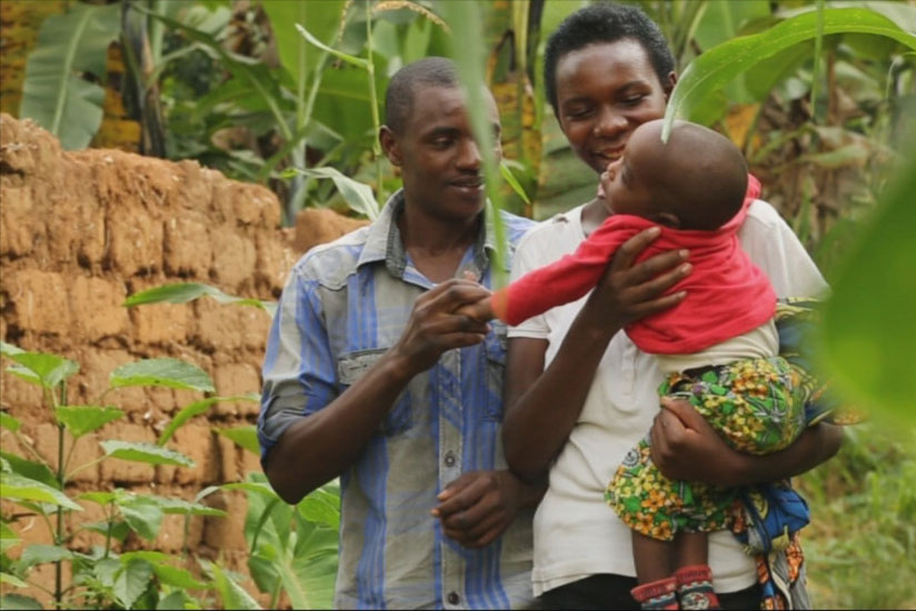 Theophile and Marceline carrying their son who is handicapped.