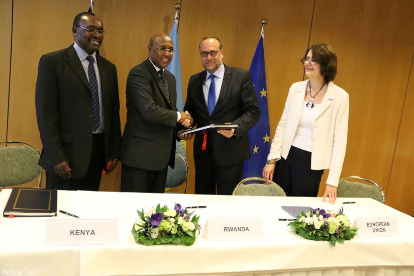 Mohamed (2nd L) and Slovakiam envoy to EU Peter Javorcik (2ndR) exchange the signed agreement as Kanimba (L) and  Sandra Galina, of the European Commission, look on. rn(Courtesy)