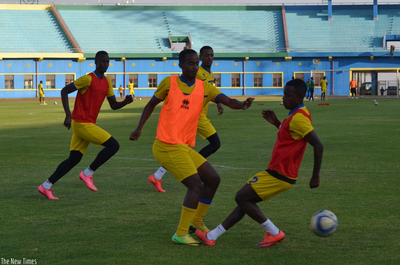 Midfielder Yannick Mukunzi tries to pull a way from a challenge by defender Michel Rusheshangoga on Wednesday at Amahoro stadium. (Sam Ngendahimana)