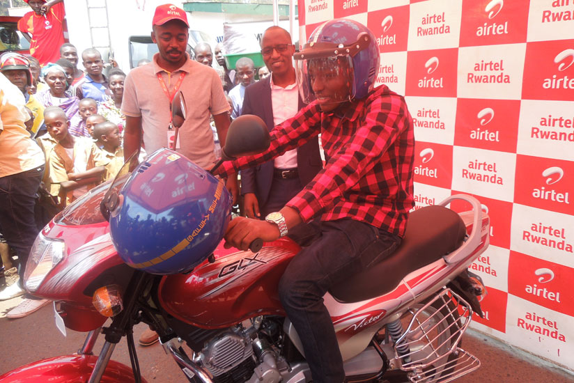 Viateur Irambona tries out the motorbike he won in the promotion. / Appolonia Uwanziga