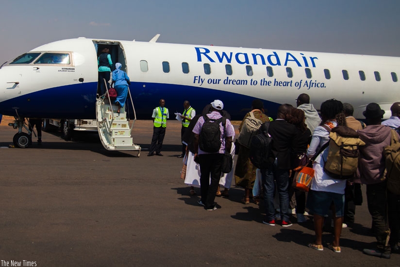 Passengers board a RwandAir plane heading to Cotonou at Kigali International Airport. / Nadege Imbabazi.