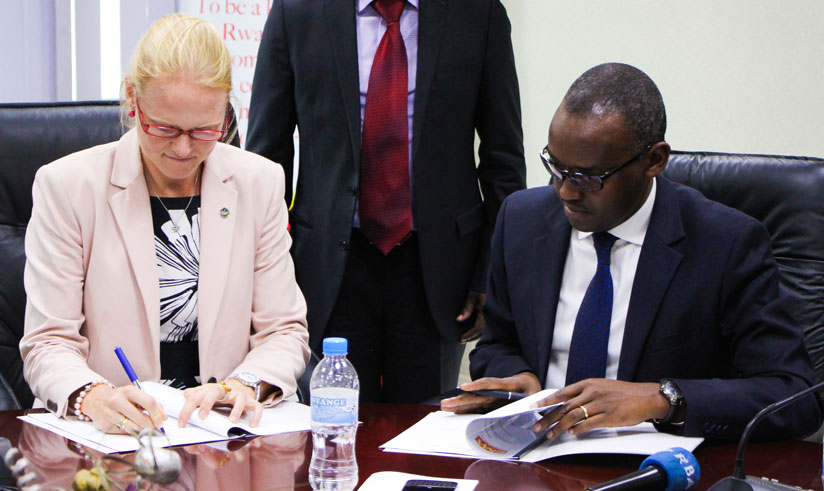 Green signs documents with Eric Rwigamba of MINECOFIN in Kigali last week (Nadeje Imbabazi)