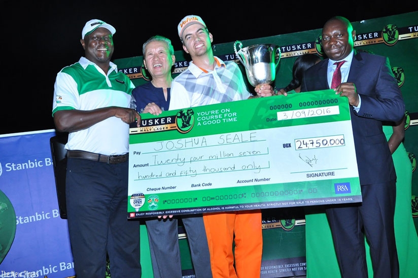 Joshua Seale is handed his winneru2019s cheque by the UBL MD Mark Ociti (L) and the president of the Uganda Golf Union Johnson Omolo (R). (Courtesy)