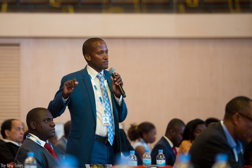 A participant asks a question during a panel discussion. / Timothy Kisambira.