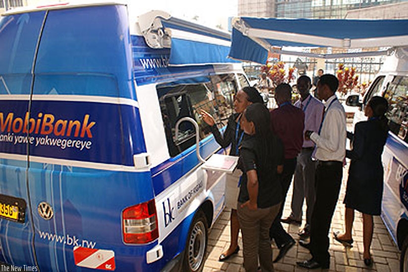 New clients consult bank officials at Bank of Kigali mobile banking van recently. (File)