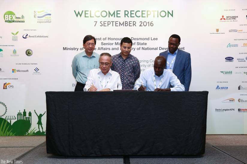 Sagashya and Choo Watt Bin sign the agreement as other officials look on. (Courtesy)