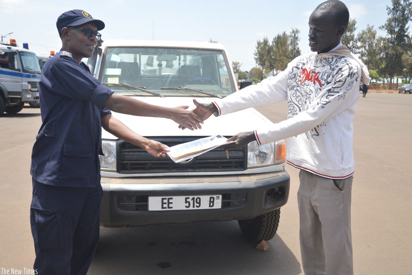 Kulamba (L) hands over the vehicle to Deng at RNP headquarters in Kacyiru. (Courtesy)
