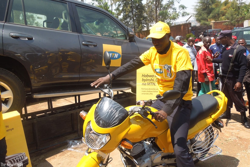 Regis Muramira tries out a motorbike he won in the promotion. (Appolonia Uwanziga)