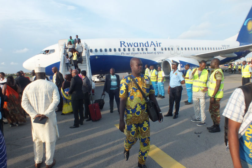 Passengers disembark from a RwandAir flight upon landing in Cotonou, the capital of Benin, officially marking the launch of the national flag carrier's flights to the West African ....