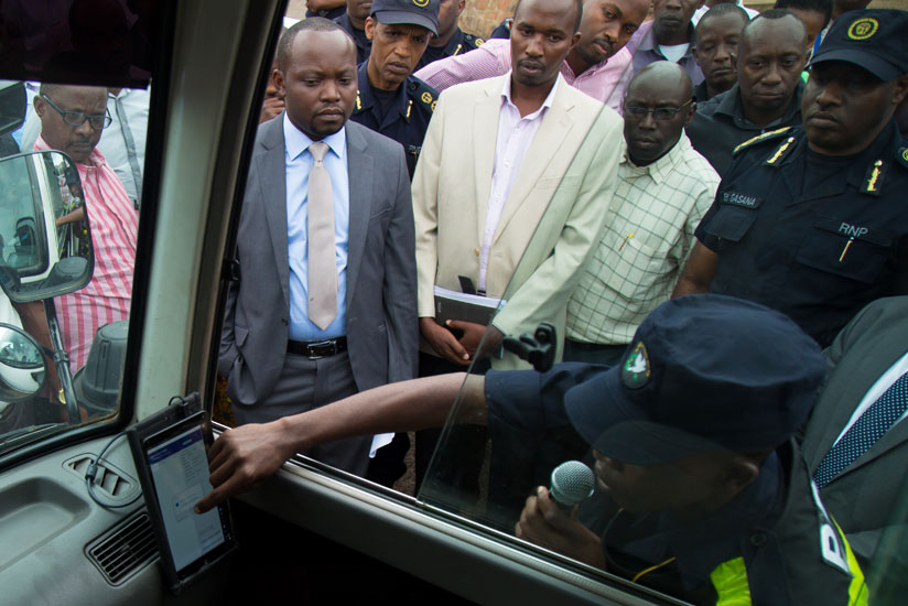 A traffic officer shows government officials how speed governors will work in public vehicles. (Timothy Kisambira)