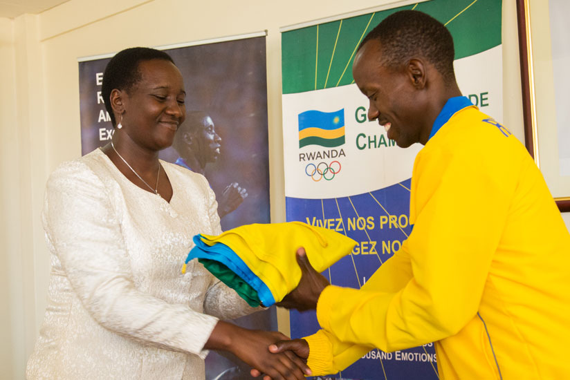 Muvunyi receives the national flag from Sports and Culture minister Julienne Uwacu ahead of the Paralympics team departure for Rio. / Faustin Niyigena.