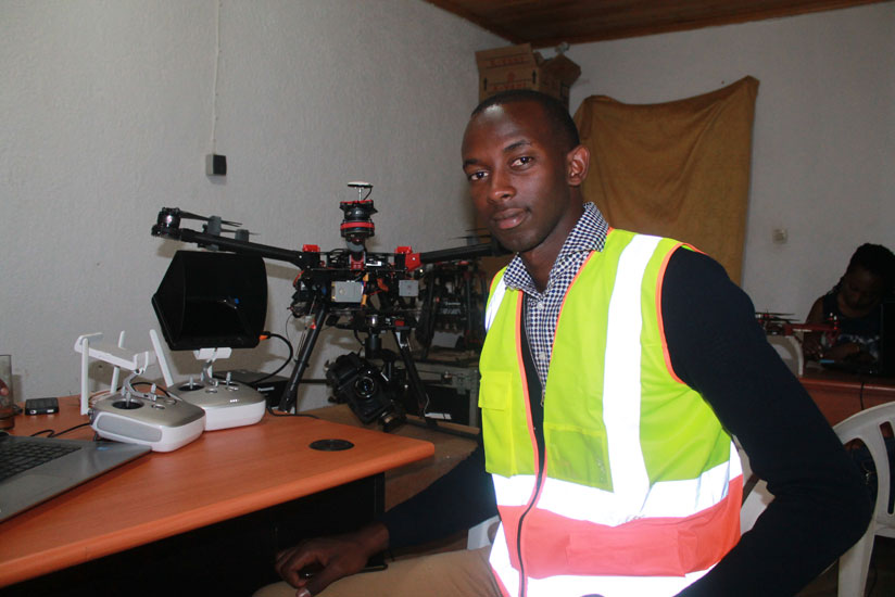 Teddy Segore poses by one of the drones he pilots. / Moses Opobo