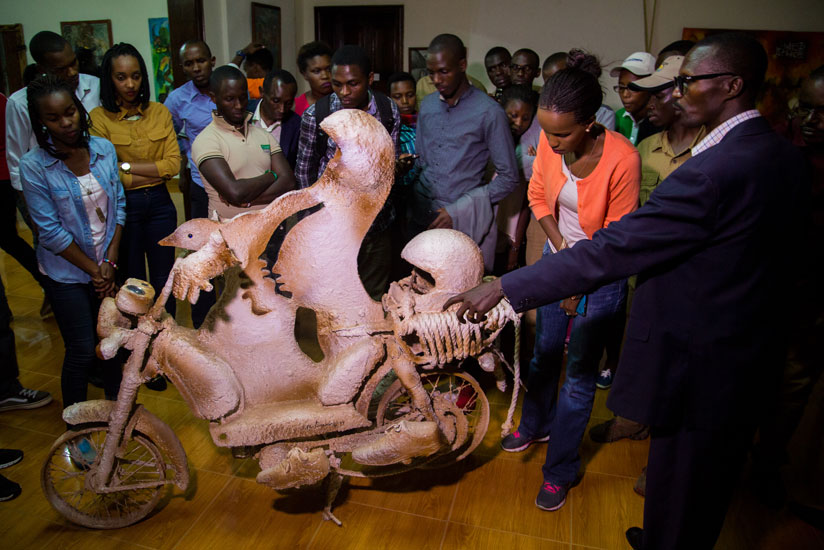 A guide at the National Art Gallery explains one of the tourist attractions at King Mutara III Rudahigwa's Palace in Nyanza. The government has started a campaign called 'Tembera U....