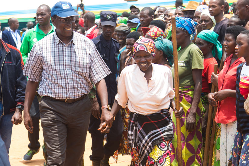 Makuza (L) shares a light moment with a resident of Karama Sector during the event to mark the ninth anniversary of Unity and Reconciliation Week on Saturday. / Faustin Niyigena.