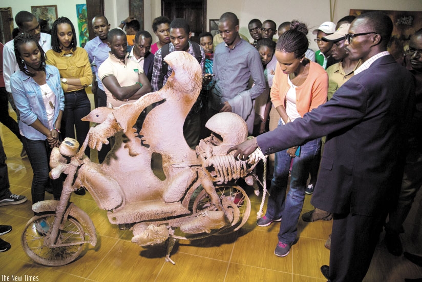 A guide explains to local tourists about his artwork at the Nyanza museum last week. (File)