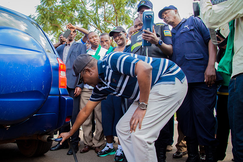 The Minister for Natural Resources, Dr Vincent Biruta, tests levels of carbon emissions from a car as police officers verify if the results match with the environmental standards. / File.
