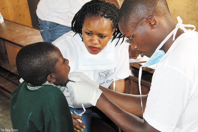 Medics examine a child with dental problems. / Lydia Atieno.