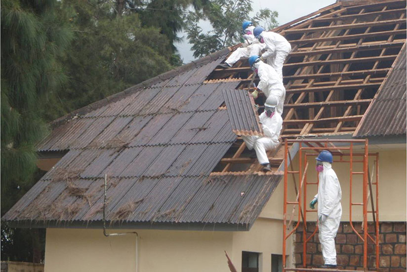 Technicians remove asbestos roofing material off a building at Gishari PTC. / File