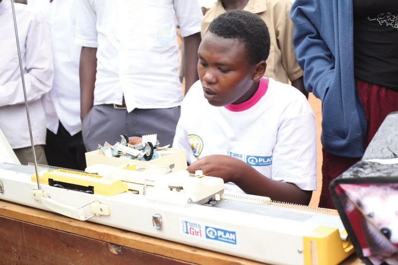 A girl uses a knitting machine donated to her by Plan International Rwanda during the International Girl Child Day celebrations in Gatsibo District on Tuesday. / Kelly Rwamapera.