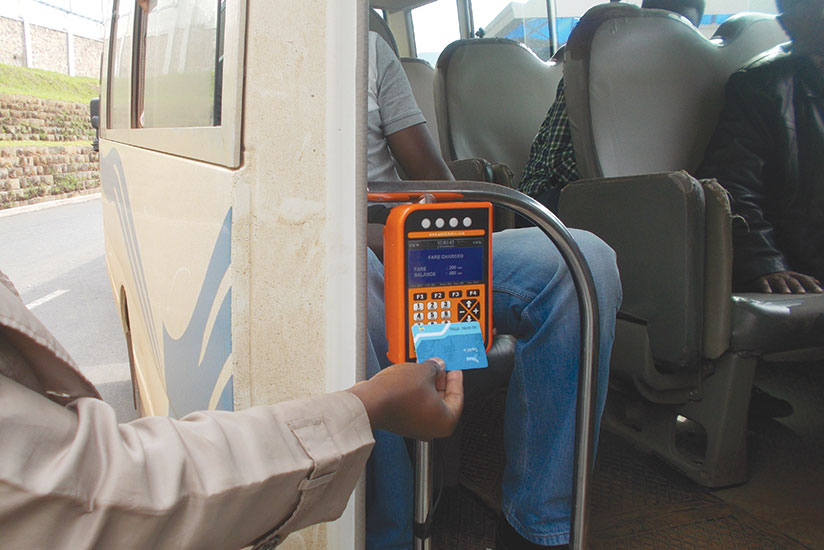 A passenger swipes his card on the device in one of public transport buses in Kigali on Monday. / Elias Hakizimana.