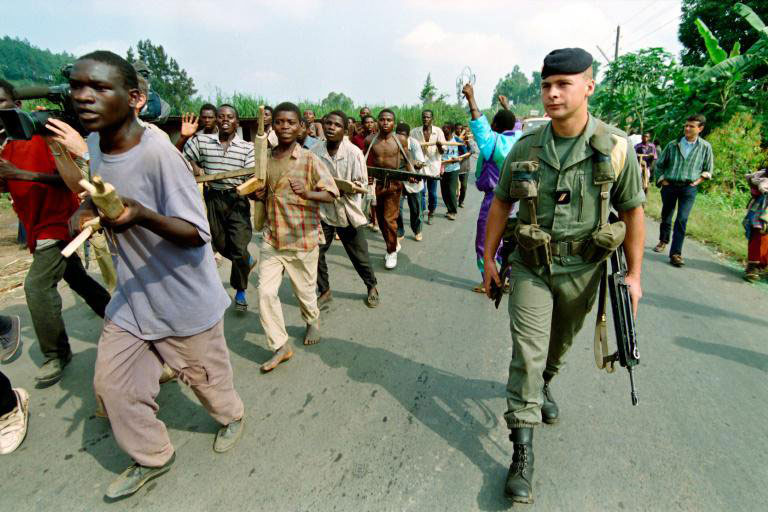 Interahamwe militia train as a French soldier looks on in 1994. / Net photo