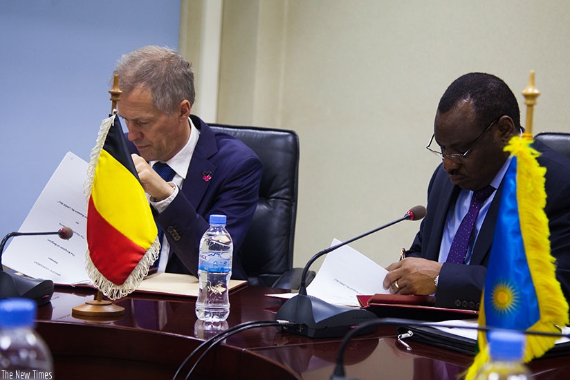 Gatete (R) and Amb. Pauwels sign the financial agreement in Kigali, yesterday. N. Imbabazi. File. 