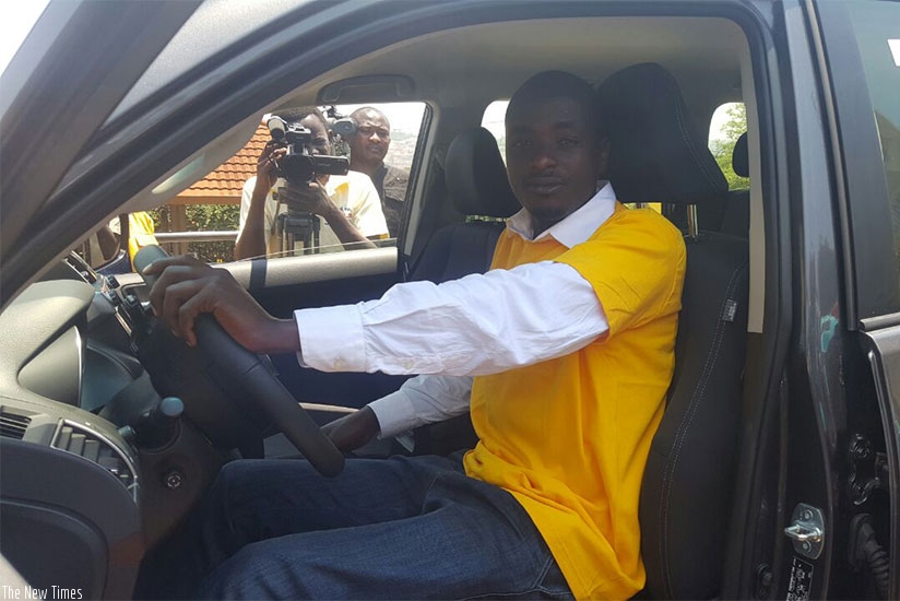 Shumbusho tries out the car at the telecom firmu2019s head offices in Kigali. (Courtesy.)