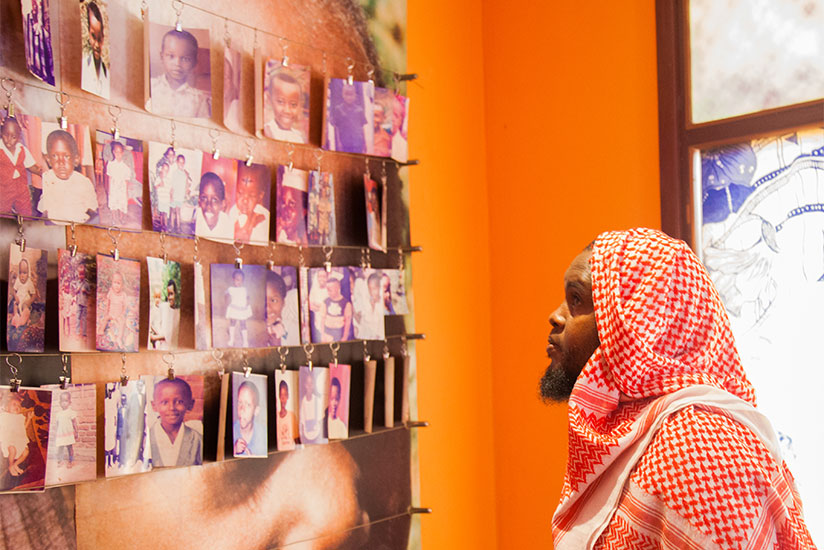 A visitor looks at photos of children killed during the 1994 Genocide against Tutsi at Kigali Memorial Centre in Gisozi. / Nadege Imbabazi