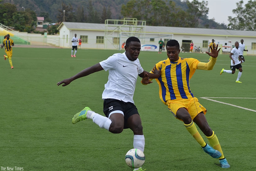 Muhadjiri Hakizimana, left, controls the ball under pressure from Amagaju defender on Sunday at Kigali Regional 