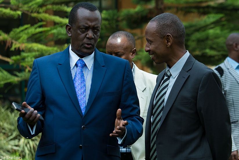 Maj Gen James Mugira (L), managing director of National Enterprise Corporation in Uganda chats with Eugene Haguma, chief executive of Horizon Group, at a meeting of chief executive....