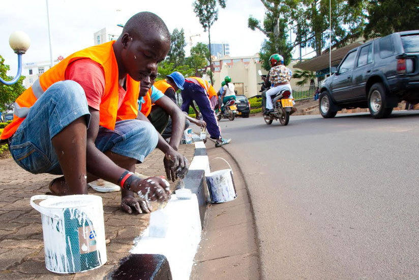 Workers painting a pedestrian foot path.