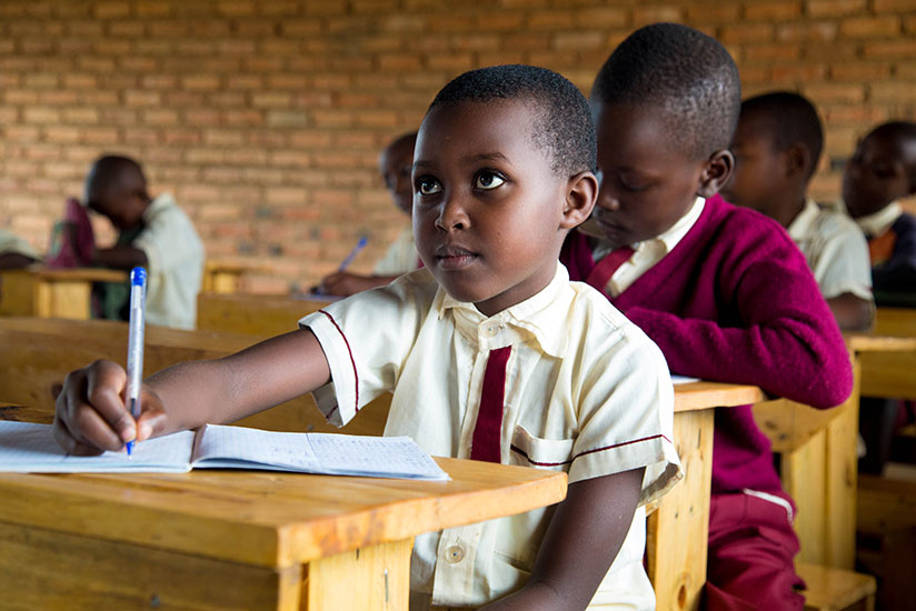 A pupil takes notes during class at Rusheshe Primary School in Kicukiro District. / Timothy Kisambira