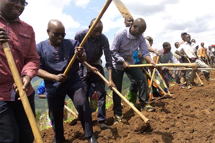 Minister Nsengimana (Second L) joins the youth and Rulindo District residents to clear a road during the Umuganda exercise in Cyisaro Sector on Saturday. / Emmanuel Ntirenganya