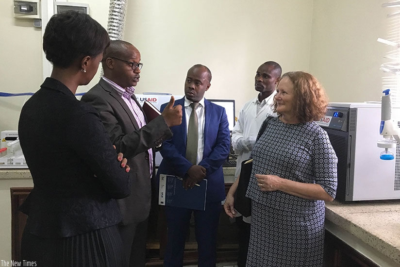 Officials get a demonstration of the testing equipment by Antoine Mukunzi, RSBu2019s division manager of national quality testing laboratory services. (Rhiannon Snide)