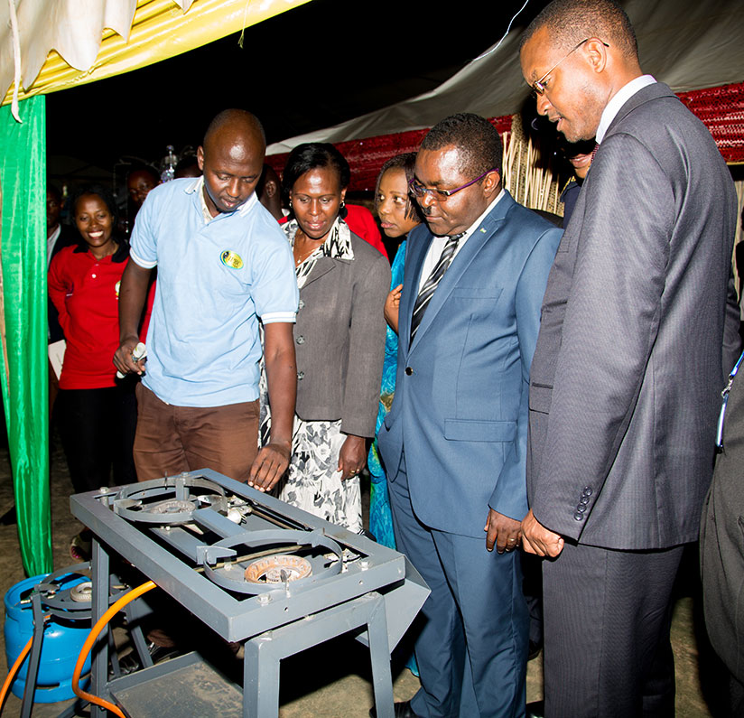 Munyeshyaka (second right) and Kicukiro District and City of Kigali officials watch as an exhibitor from IPRC-Kigali lights a stove during a tour of the expo on Thursday. / Faustin Niyigena