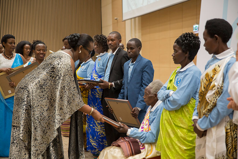 First Lady Jeannette Kagame awards one of the Abarinzi b'Igihango during the event. / Village Urugwiro