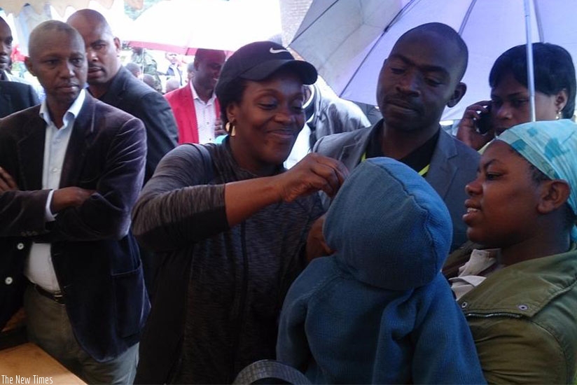 Minister Gashumba gives a deworming pill to a child in Nyabihu. (Photos by Diane Mushimiyimana)