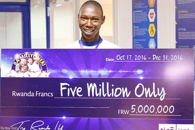 Simuganwa poses with a dummy cheque for his Rwf5m prize cash. (Courtesy)