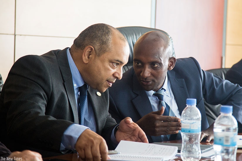 RRA  Commissioner-General Richard Tusabe (R) and  African Tax Admnistration Forum Executive Secretary Logan Wort compare notes at the meeting yesterday. (Photos by Faustin Niyigena)