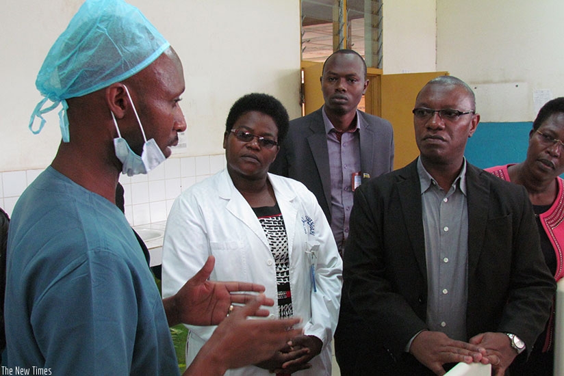 A doctor from CHUK explains to Dr Ndimubanzi about the surgeries they performed at Ruhengeri hospital. (Hudson Kuteesa)