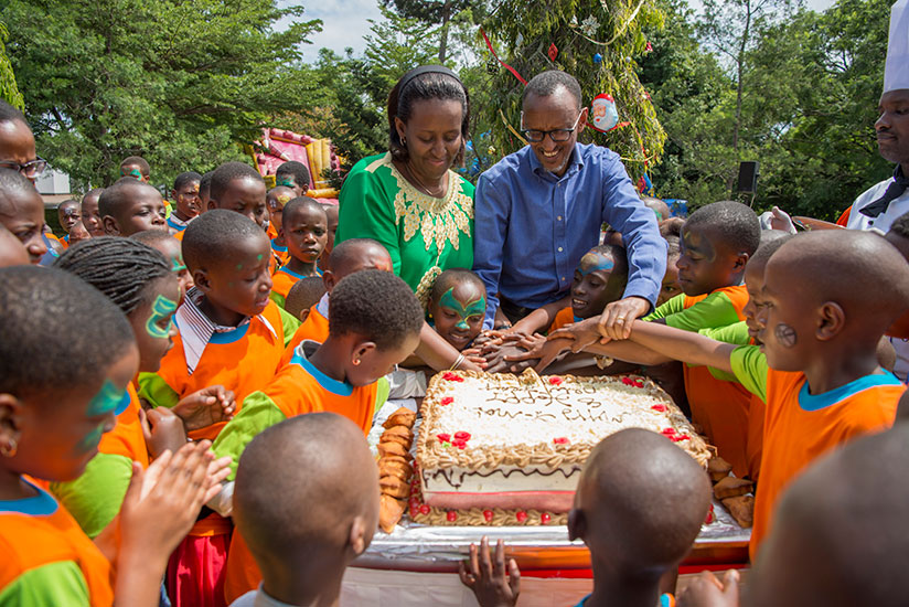 President Kagame and First Lady Jeannette Kagame help children cut End of Year Children's party cake on Sunday at Village Urugwiro. / Courtesy