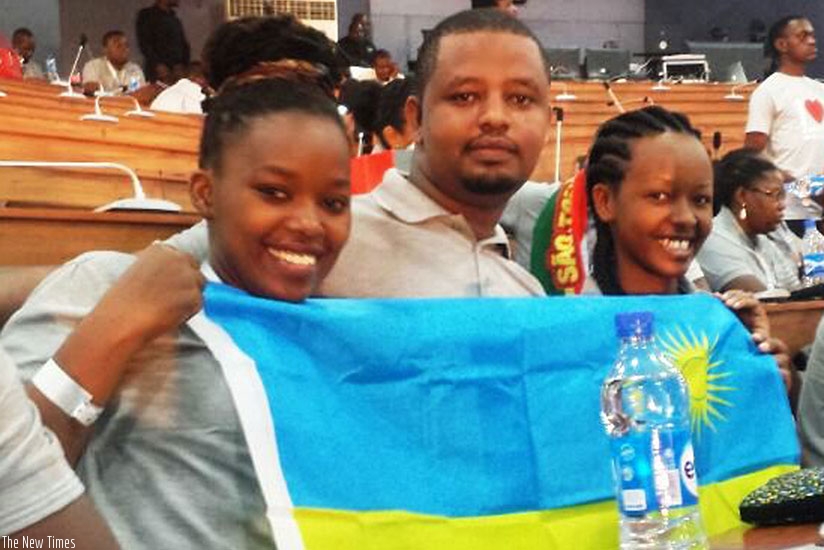 L-R: Uwineza, Nyirurugo and Ishimwe pose with the national flag at the boost camp in Lagos. (File)
