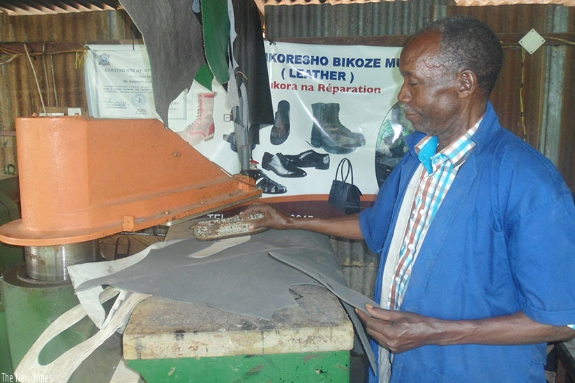 Gatorano explains how one of the machines used to make leather products works. (Photos by Remy Niyingize)
