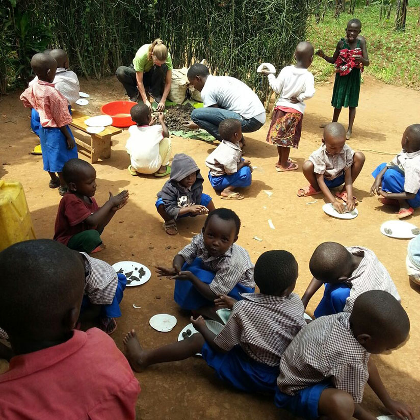 Zigama helping children to do art work. / Lydia Atieno